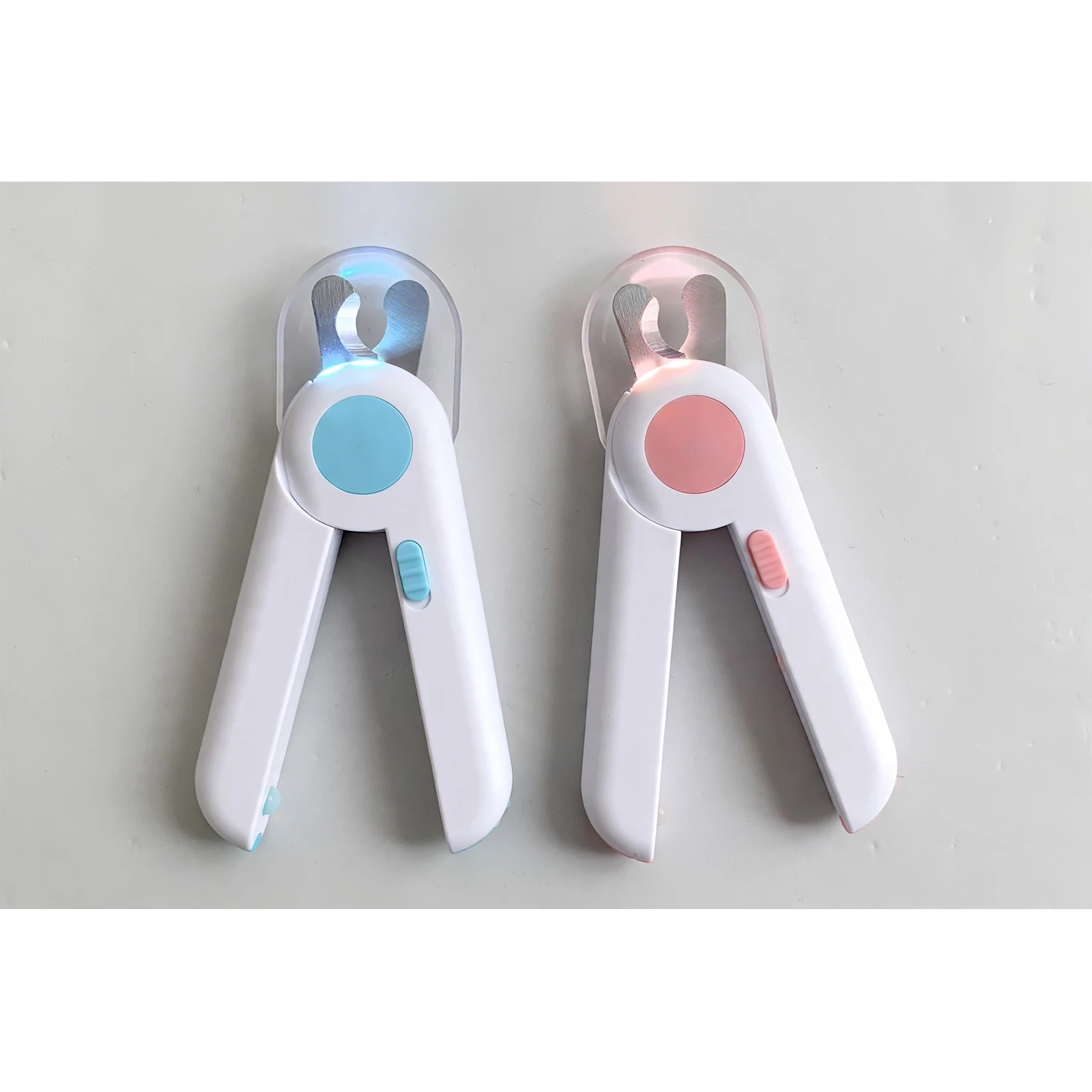 Blue and pink LED pet nail clippers with splash guards, side by side